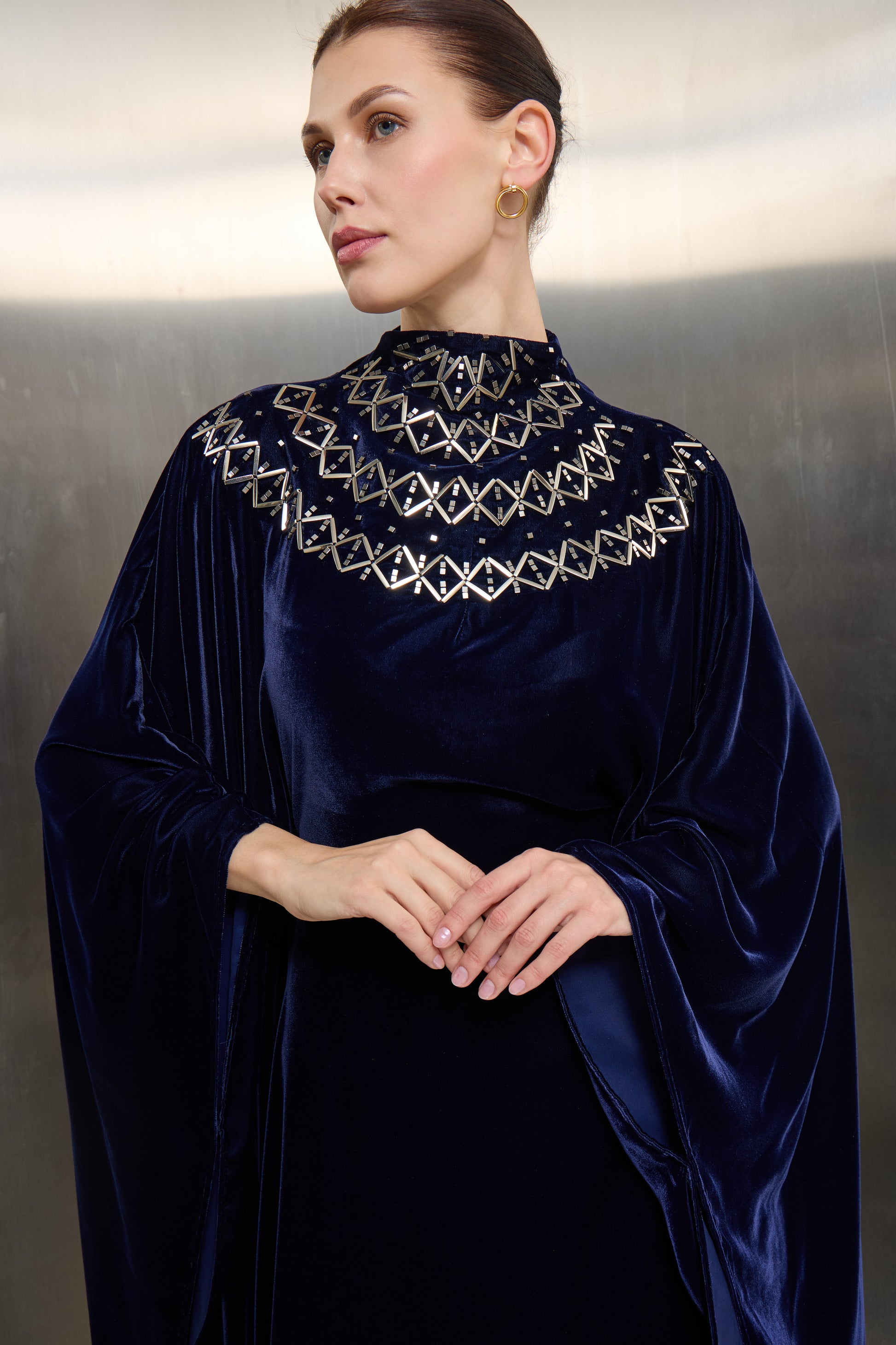 Close-up of intricate silver stone embroidery on a navy velvet collar, showcasing the signature high-craftsmanship of Mona Al Shebil’s luxury fashion line.