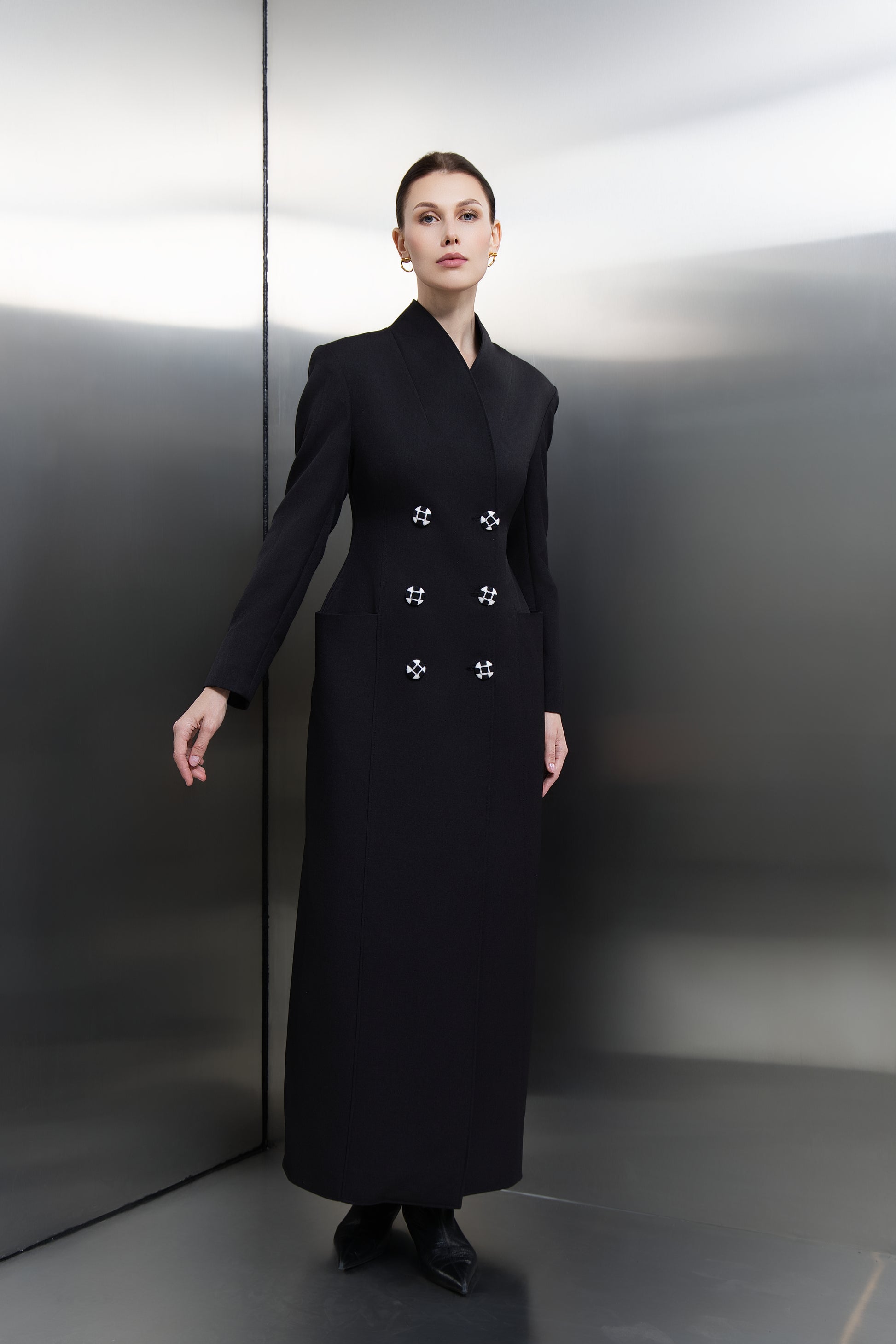 "Mona Al Shebil Black hourglass long blazer featuring a double-breasted design with unique hand-embroidered buttons, offering a powerful, tailored silhouette for the modern leader."