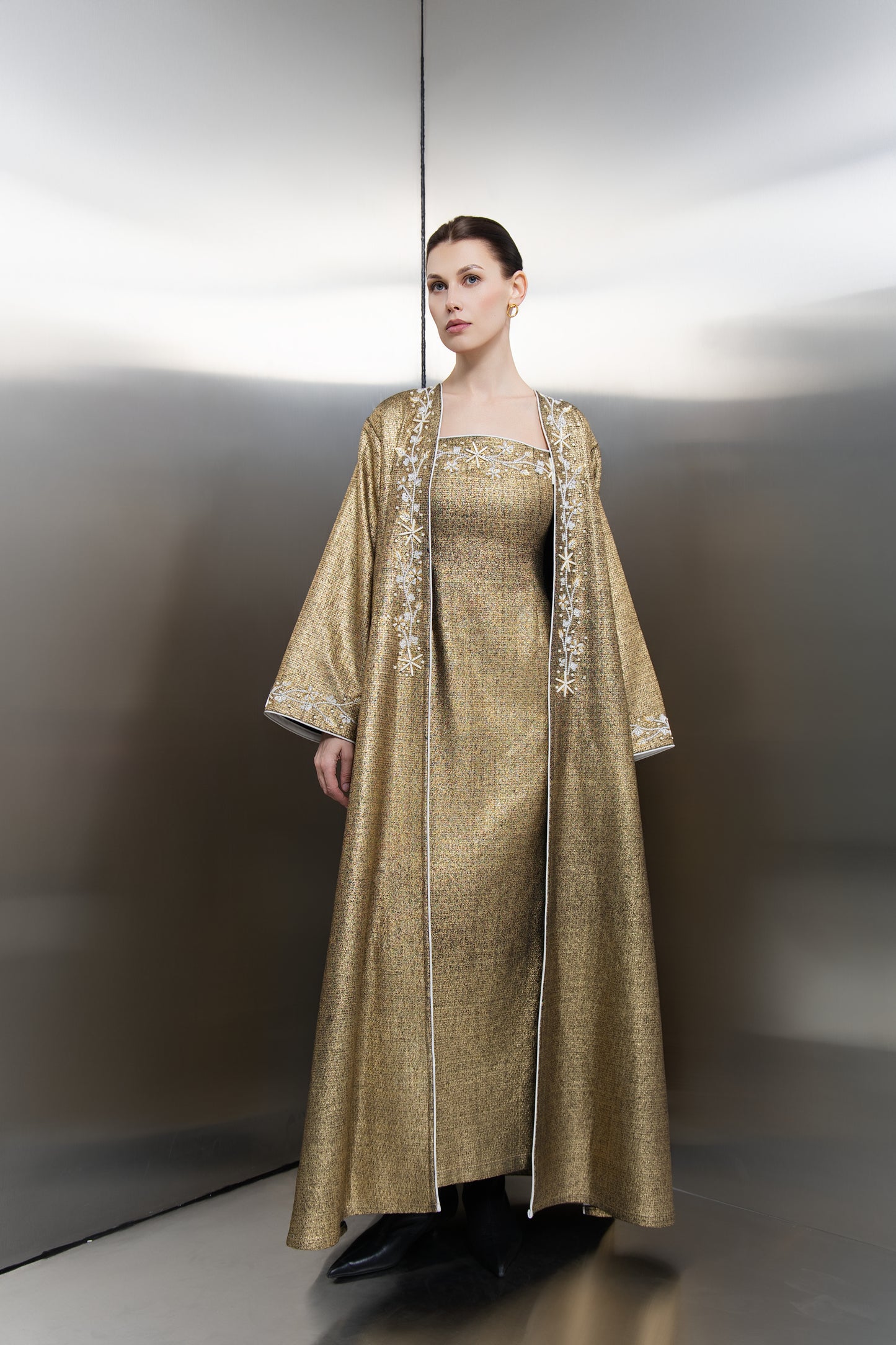 "Mona Al Shebil Kimono Embellished Gold Tweed dress set featuring a structured long jacket with wide sleeves and matching maxi dress in metallic gold weave for luxury Saudi fashion."