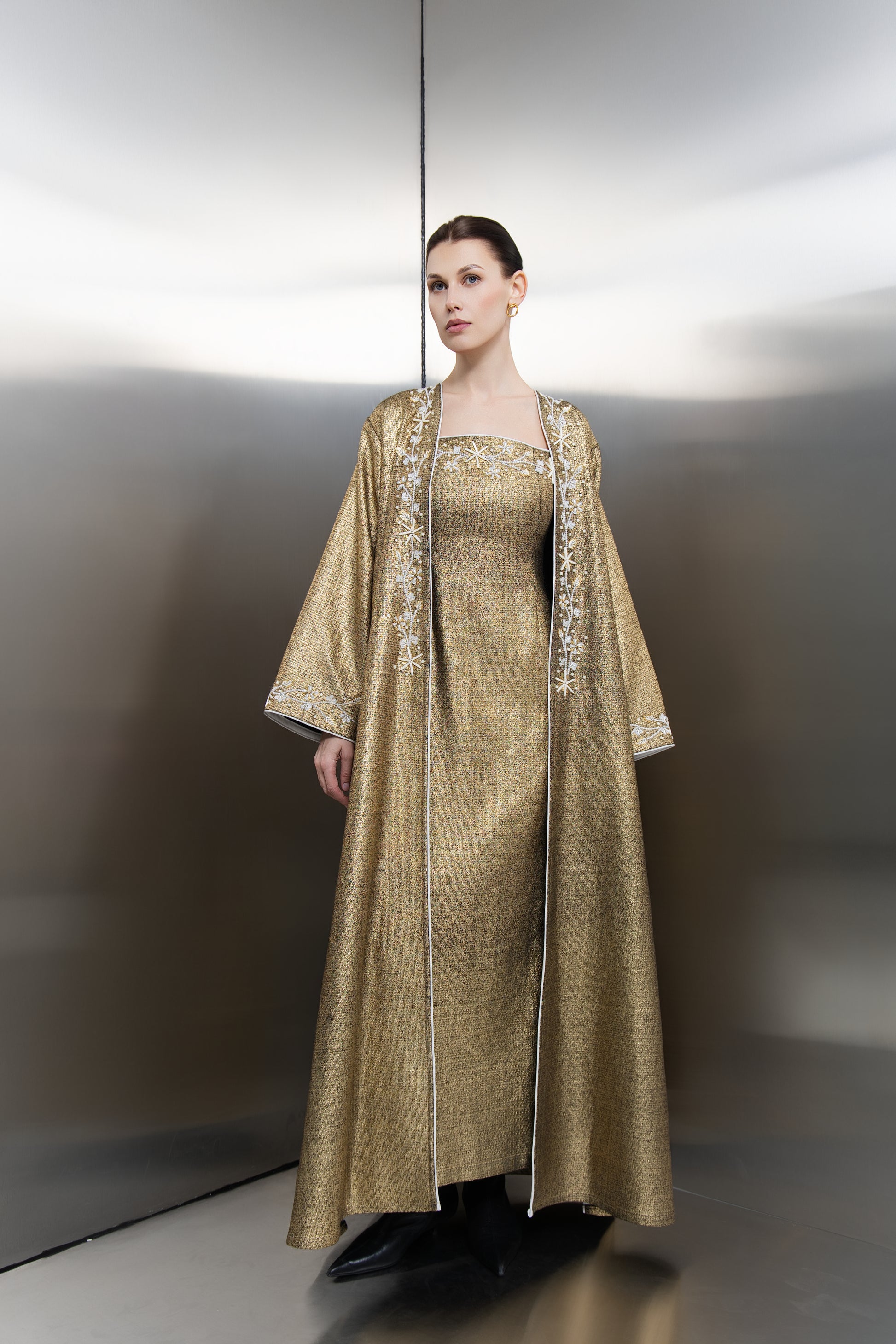 "Mona Al Shebil Kimono Embellished Gold Tweed dress set featuring a structured long jacket with wide sleeves and matching maxi dress in metallic gold weave for luxury Saudi fashion."