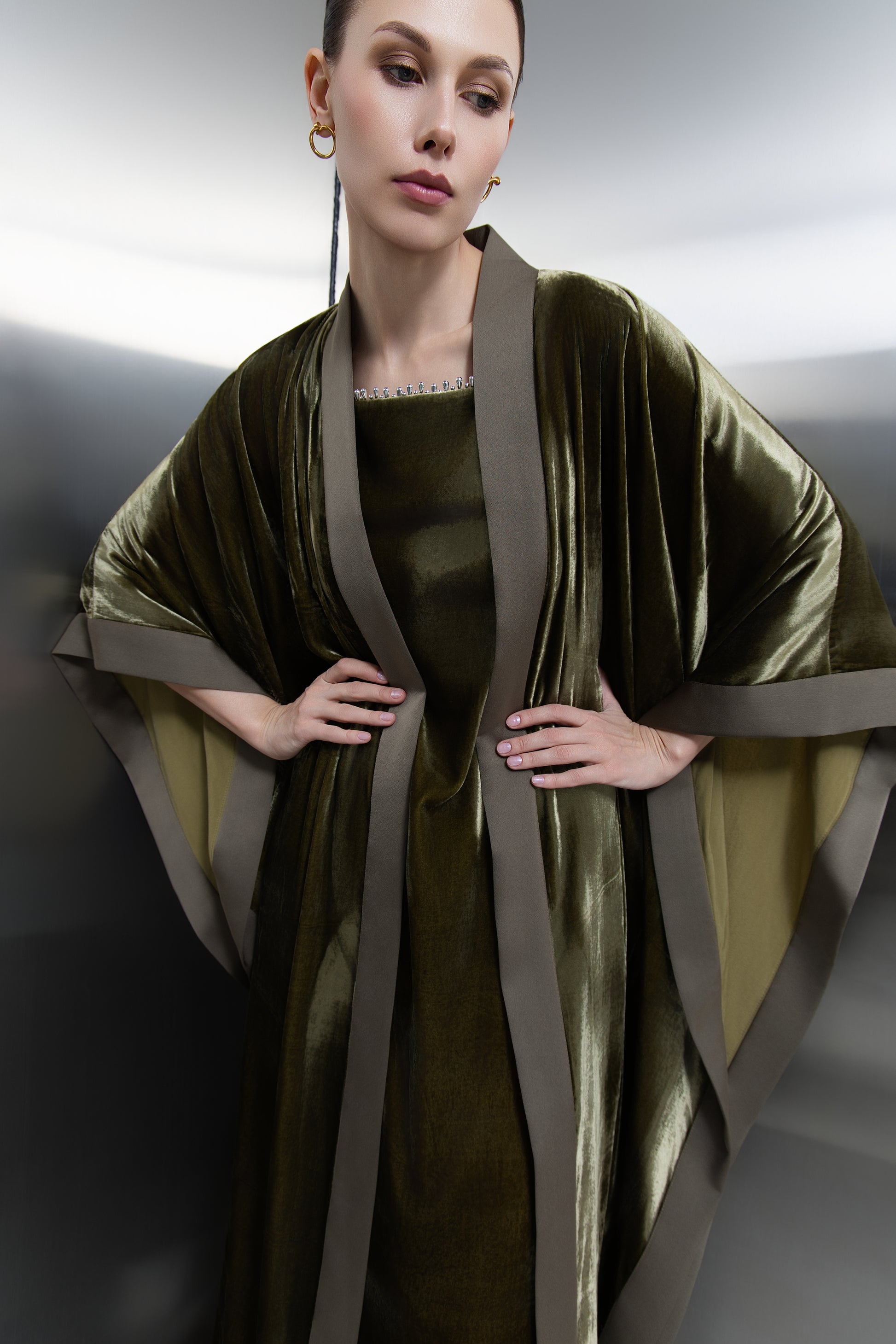 "Detailed view of the delicate silver sequin embellishment on the square neckline of the olive green velvet dress, showcasing premium Saudi craftsmanship."