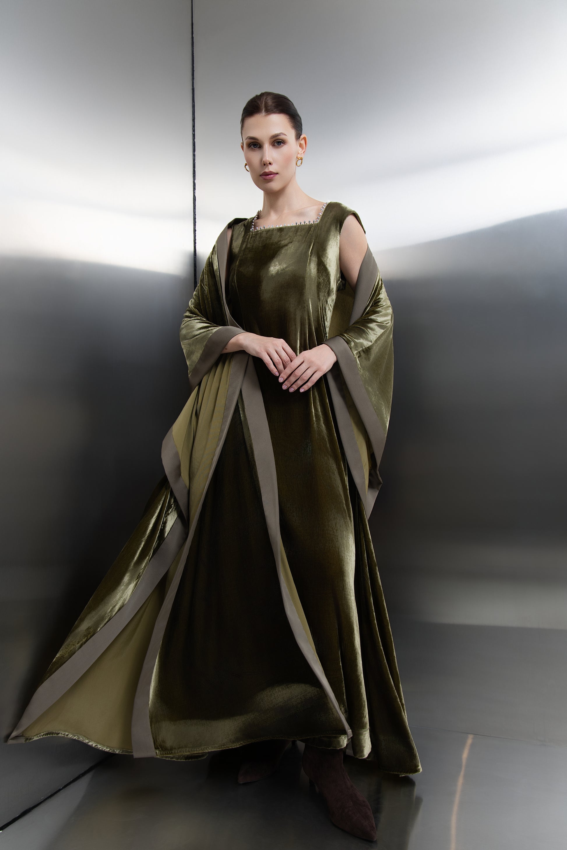 "Mona Al Shebil Olive Green velvet dress and kaftan set, featuring a sequin-embellished neckline and wide satin trim for a luxury modest evening look."