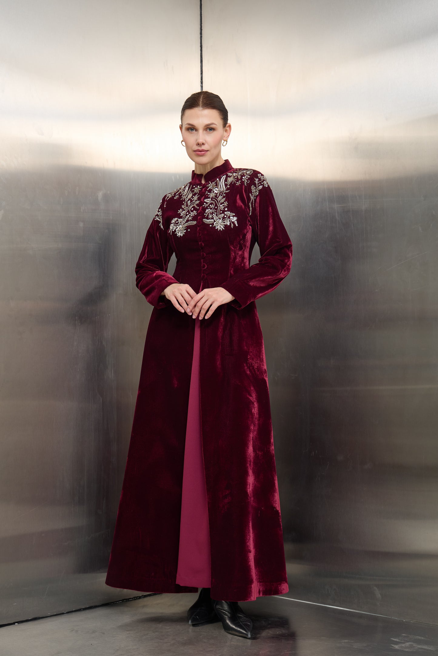 "Full-length view of the Mona Al Shebil Burgundy velvet structured jacket dress set featuring silver floral embroidery and a tailored professional silhouette for Saudi luxury fashion."