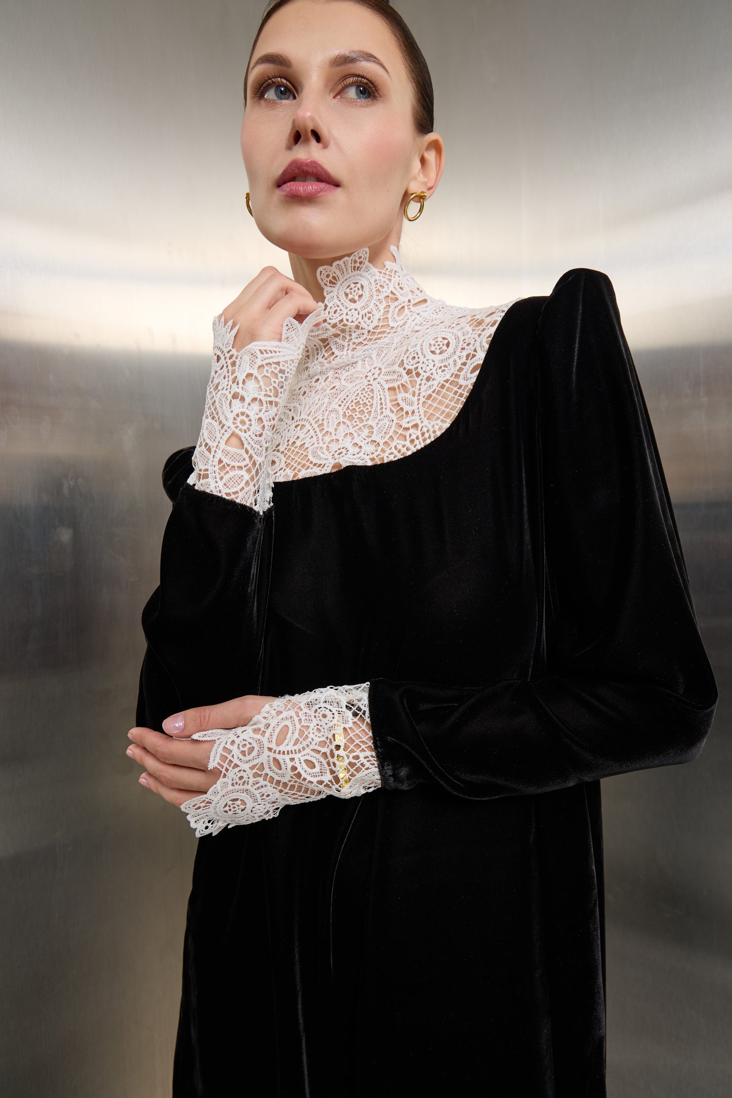 Close-up of the delicate white lace craftsmanship against the rich black velvet fabric of a Mona Al Shebil designer kaftan.