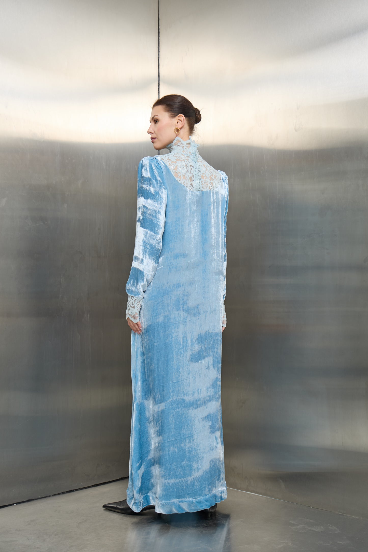 "Rear view of the light blue velvet kaftan, showcasing the tailored fit and the romantic lace detailing that defines the brand’s high craftsmanship."