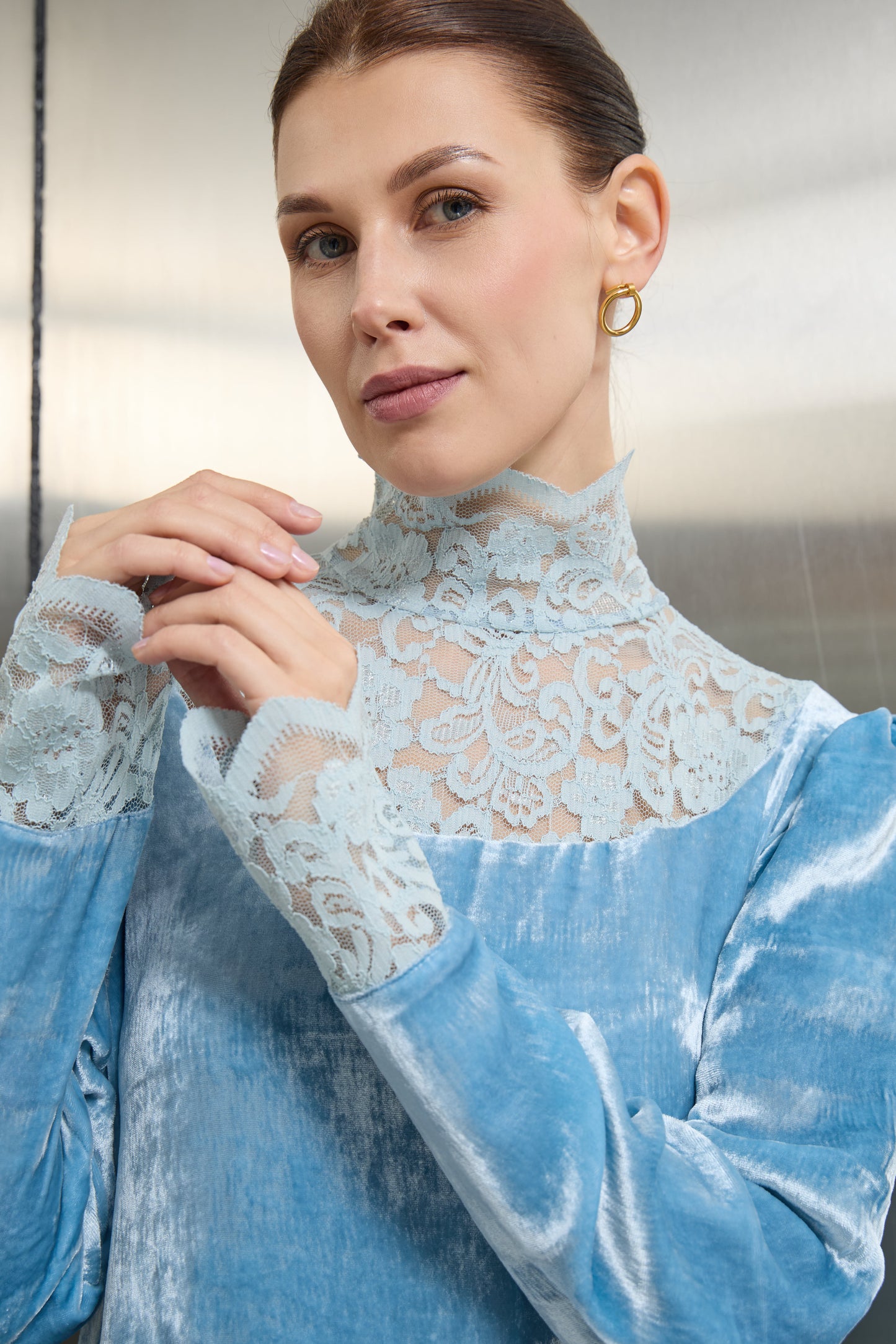"Macro shot of the fine lace embroidery on the collar of the light blue velvet kaftan, emphasizing the premium finish and sustainable design quality."