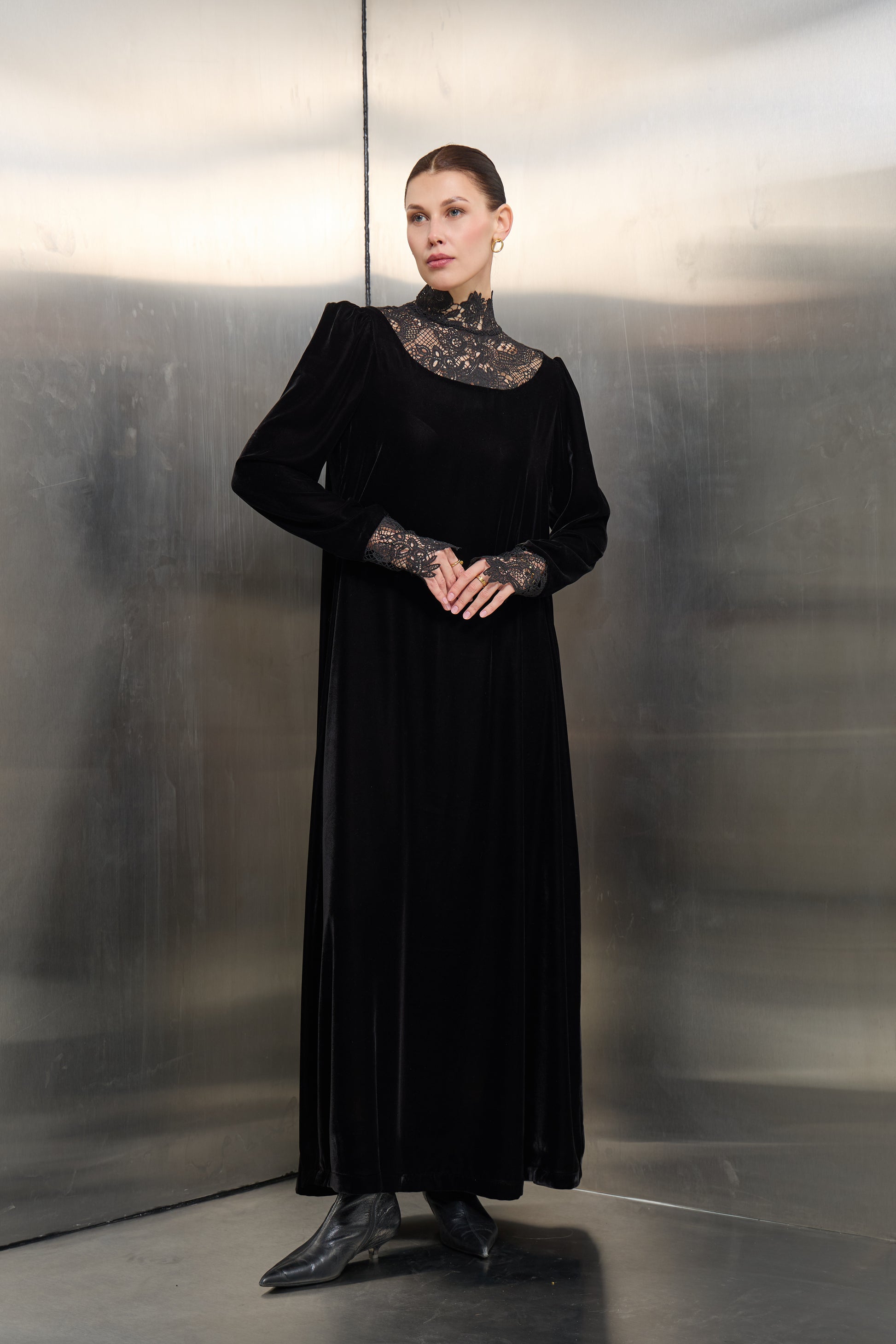 Mona Al Shebil Black velvet kaftan featuring a high-neck white lace collar and matching lace cuffs, offering a timeless luxury silhouette for formal modest occasions.