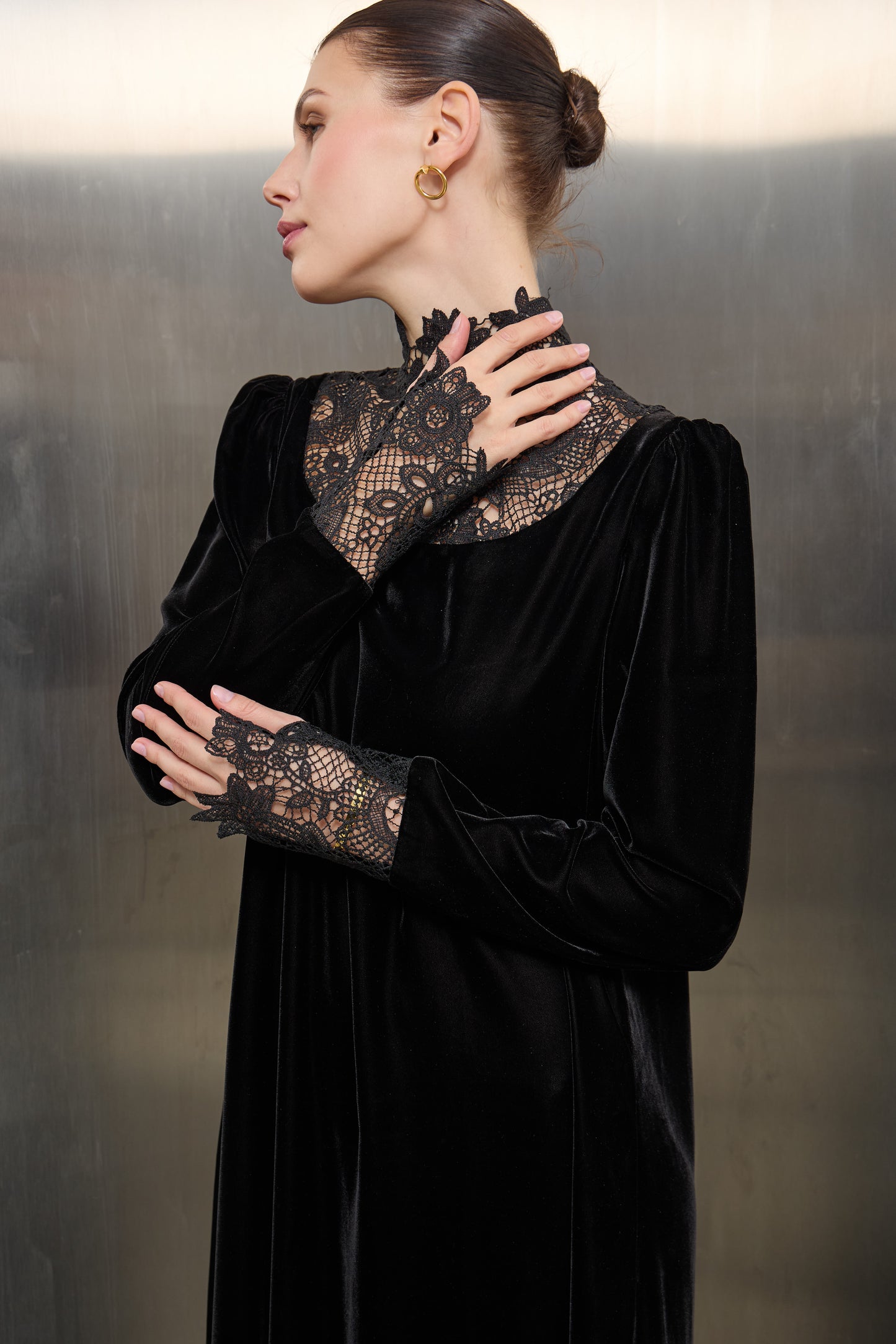 "Close-up of the delicate white lace craftsmanship against the rich black velvet fabric of a Mona Al Shebil designer kaftan."