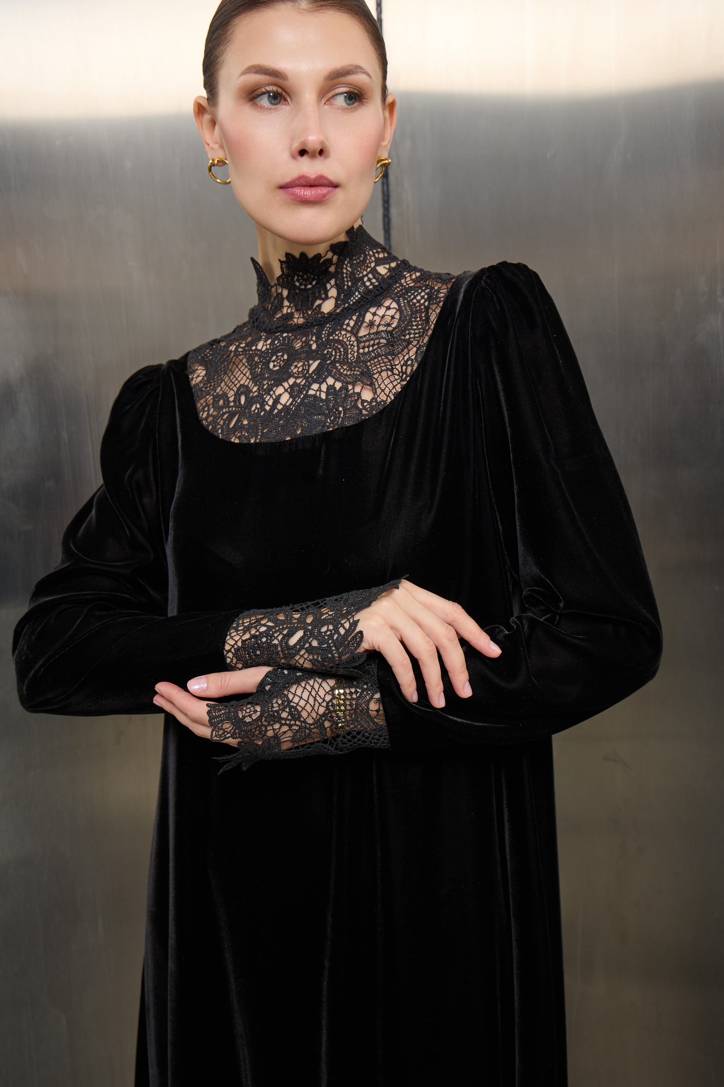 "Close-up of the delicate white lace craftsmanship against the rich black velvet fabric of a Mona Al Shebil designer kaftan."